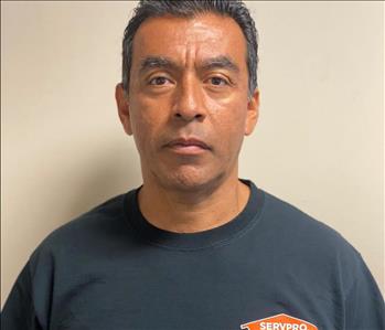 Male employee with black shirt in front of a beige wall