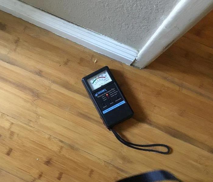 Moisture meter on brown wooden floor 