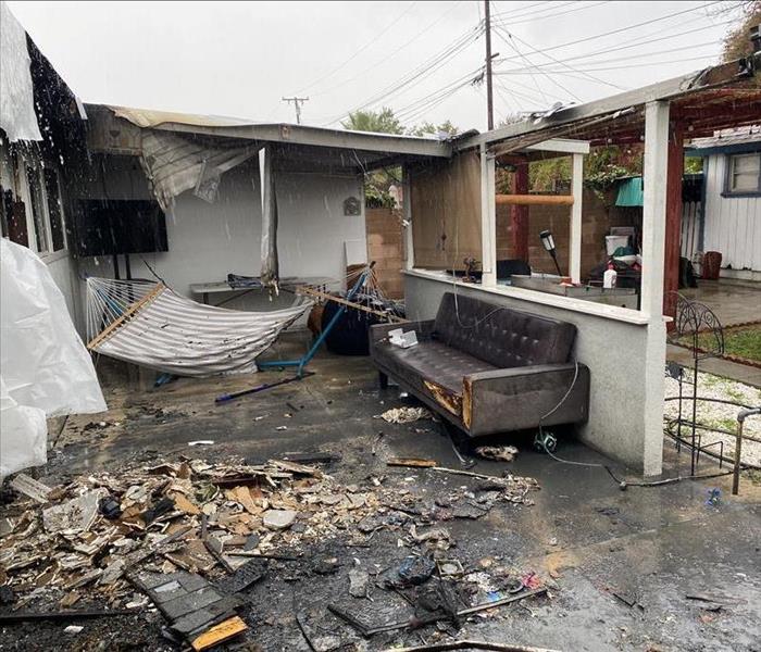 patio fire, with damages rooftop, patio furniture and debri on ground 